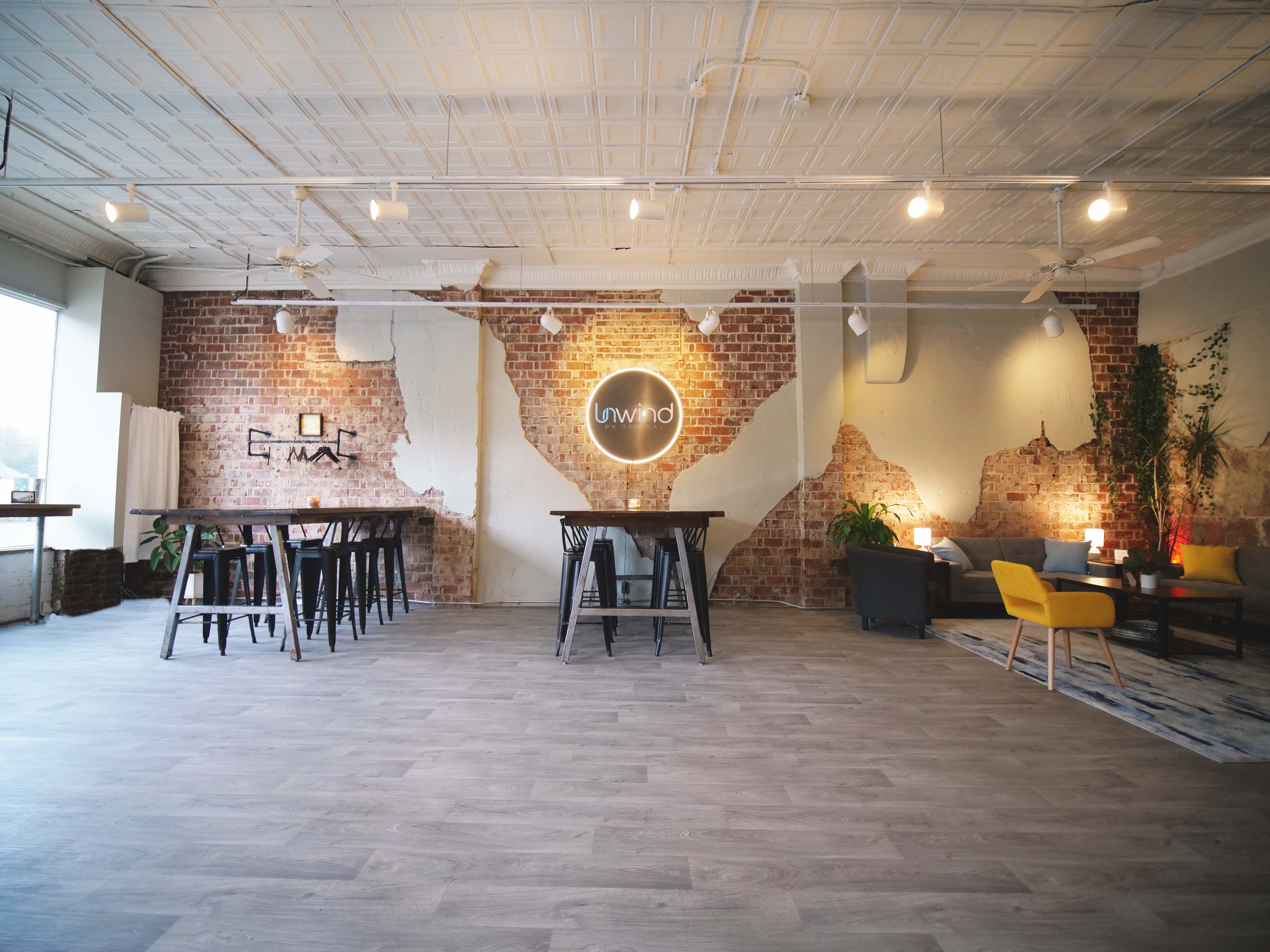 Unwind on Central venue interior with exposed brick walls and neon sign